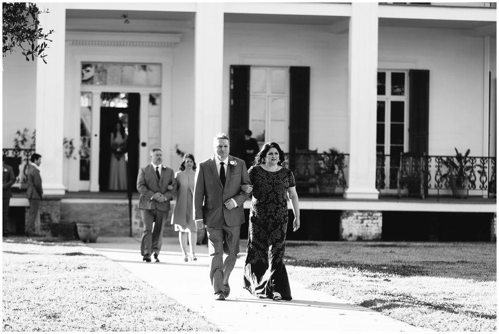 mother of the bride walks down the aisle in front of Ducros Plantation