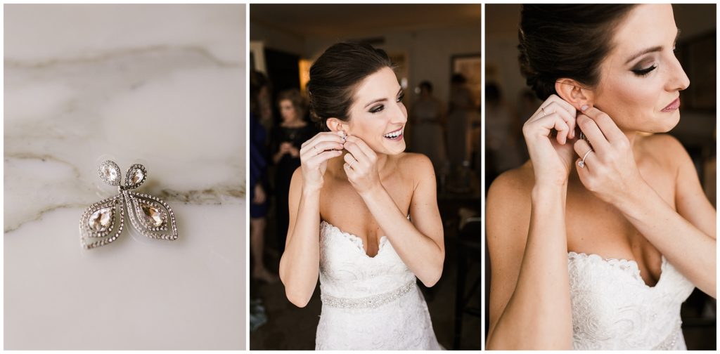 bride puts on earrings while getting ready for wedding