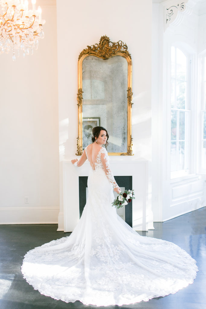 bride poses in front of fireplace at melrose mansion in new orleans