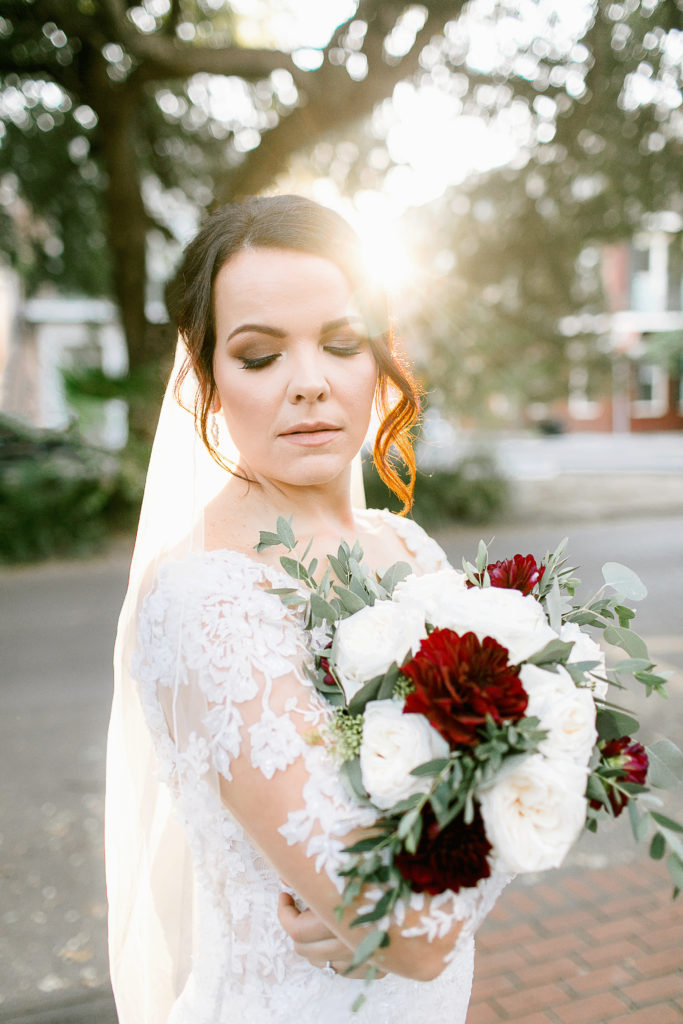 bride poses with golden hour sun flare during bridal session in new orleans
