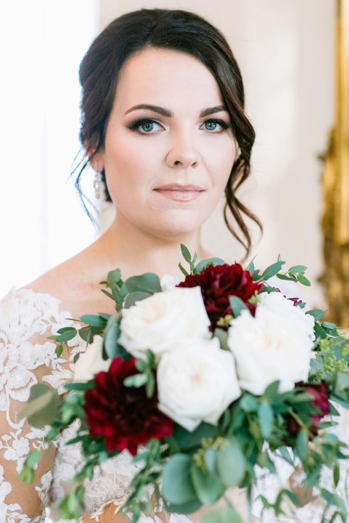 close up of bride with burgundy and white bouquet