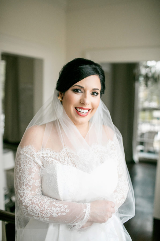 bride wraps herself in wedding veil during bridal shoot