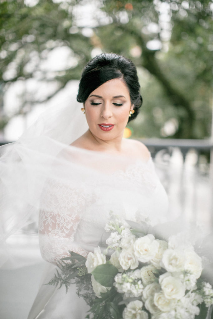 bride poses on southern porch with veil