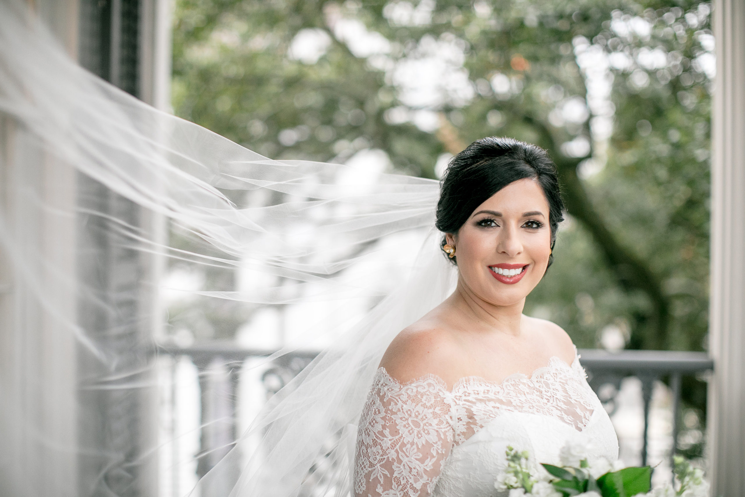bride wears windswept veil on southern porch