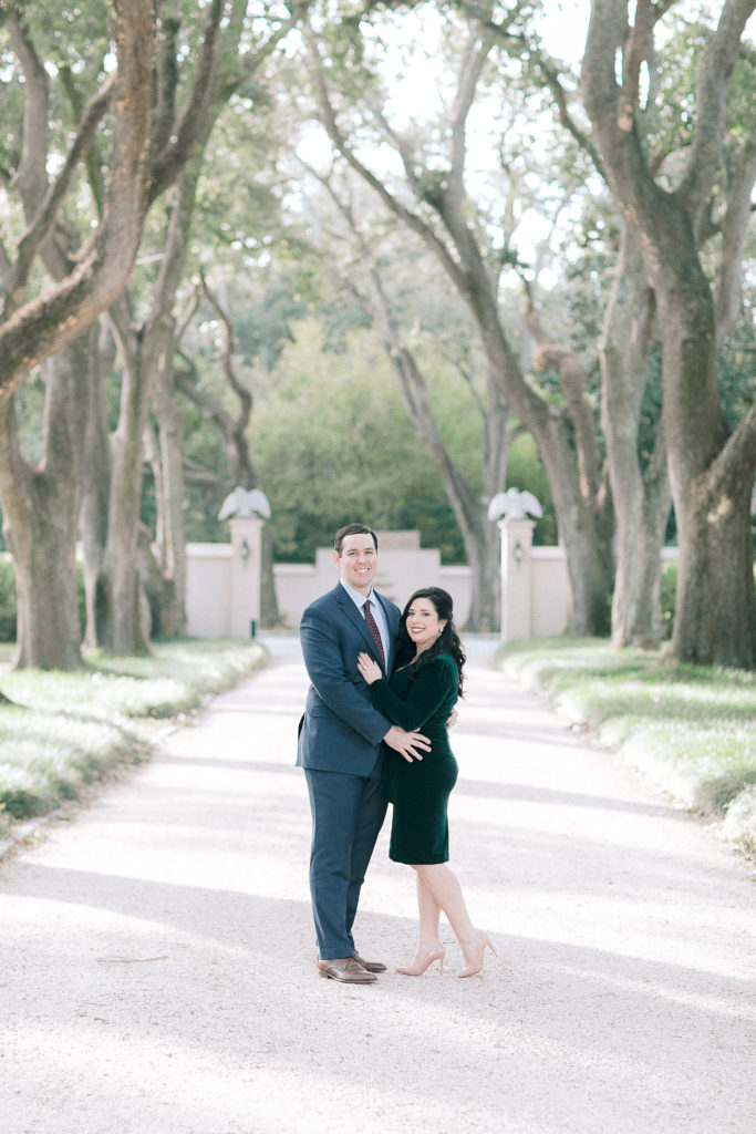 couple poses on oak lined path at Longue Vue house in New Orleans