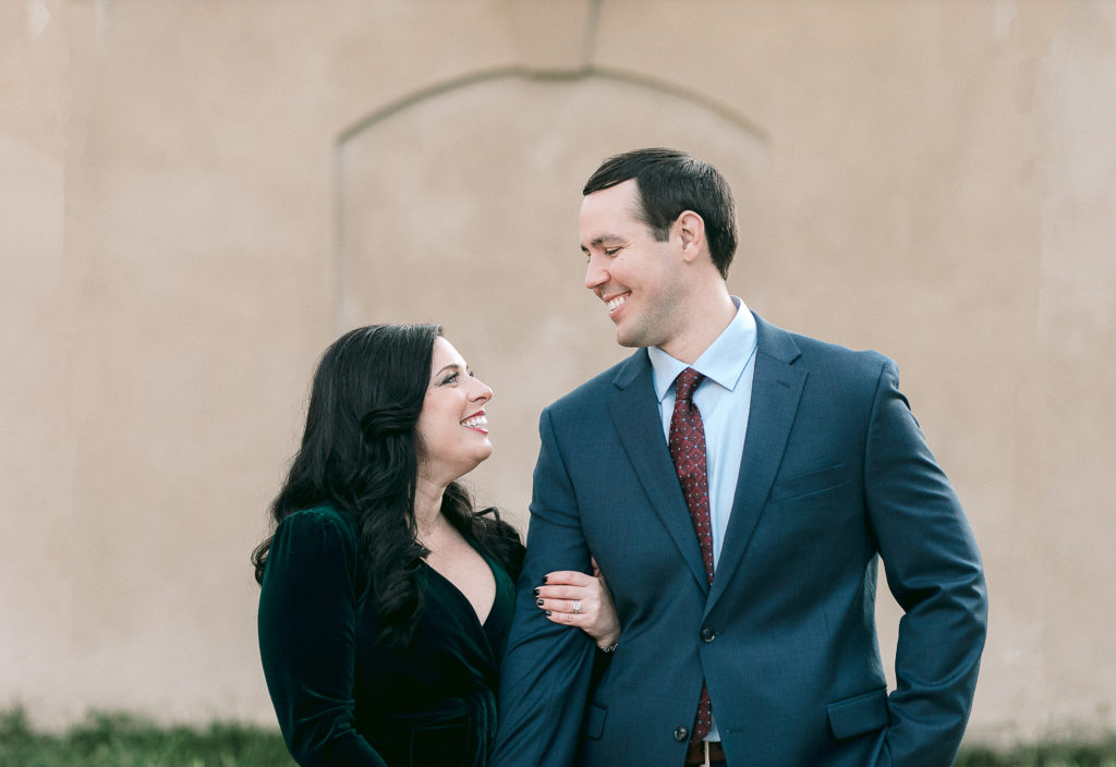 engaged couple smiles at each other during winter engagement session