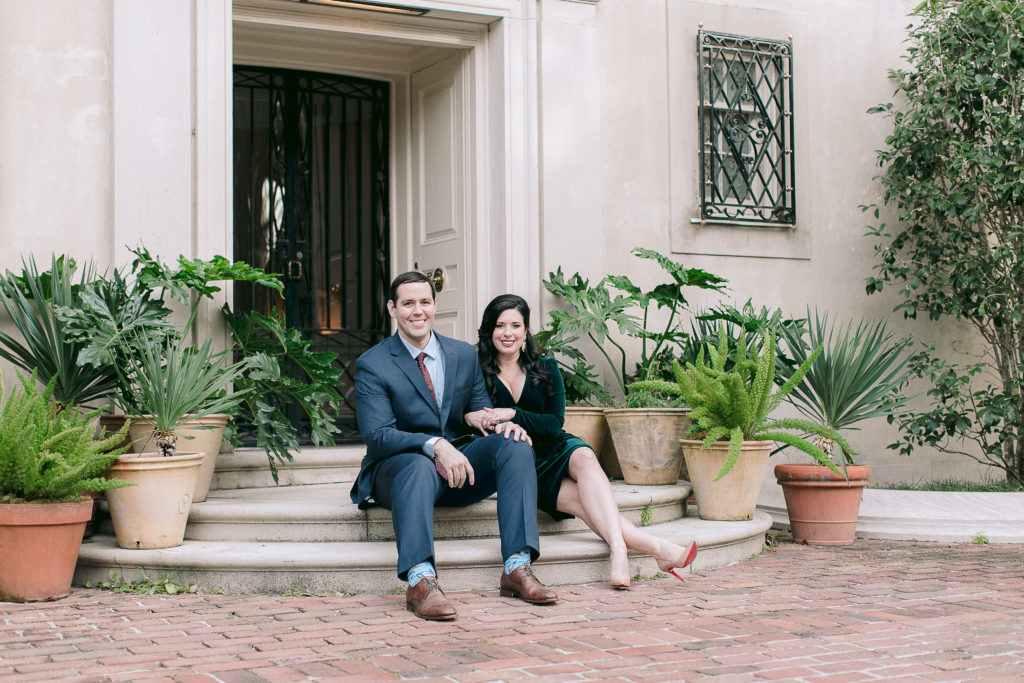 engaged couple sits in front of Longue Vue house in New Orleans