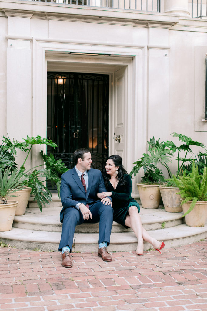 engaged couple sits in front of Longue Vue house in New Orleans