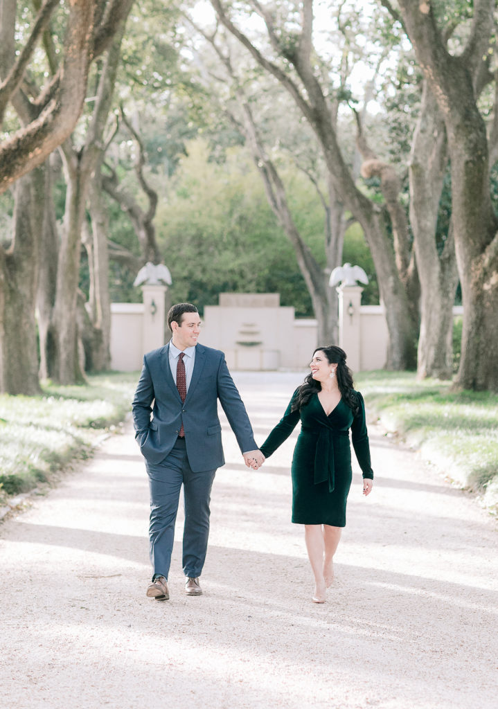 couple walks down oak lined path at Longue Vue house in New Orleans