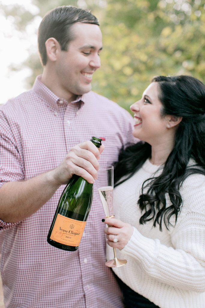 engaged couple toasts with Veuve Cliquot champagne